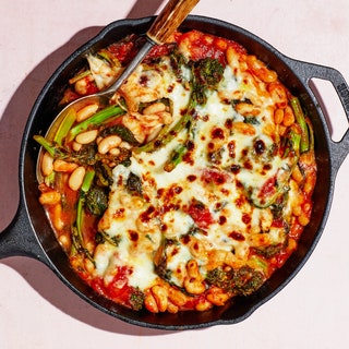 Easy dinner idea A castiron skillet filled with white beans and green beans in a tomato sauce blanketed with melted cheese.