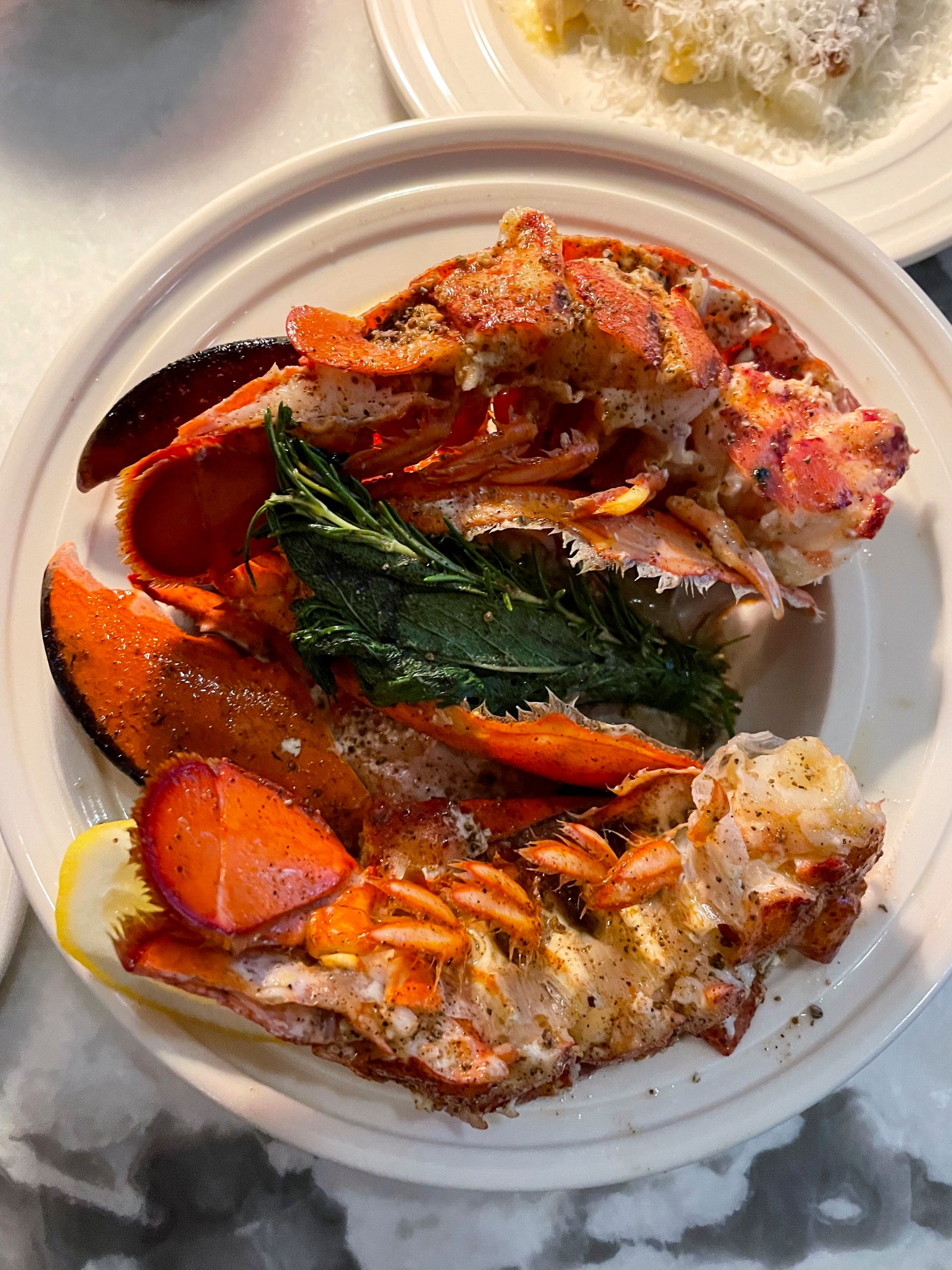 Whole lobster from the Penny on a white plate.