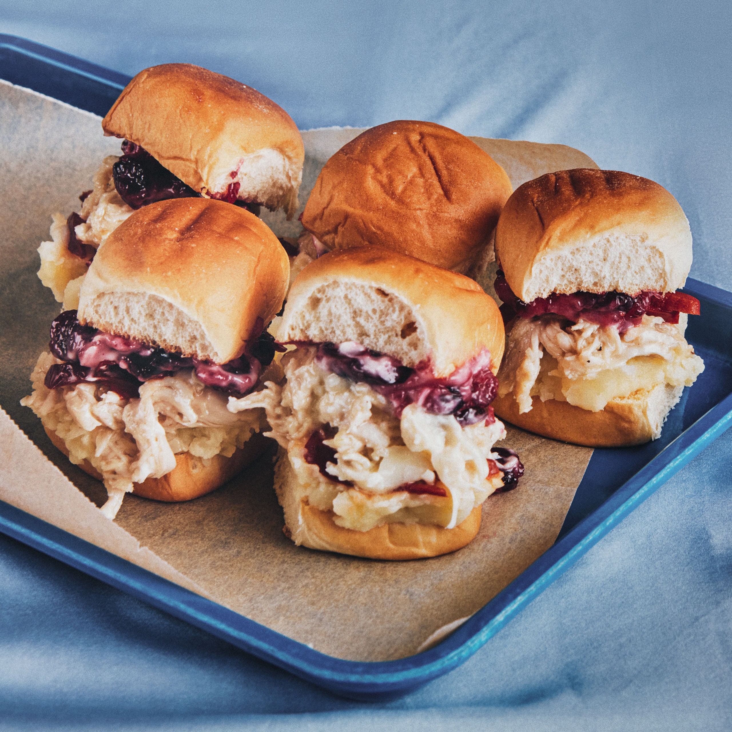 Sandwiches with shredded turkey melted provolone cheese cranberry sauce and pickled hot cherry peppers.